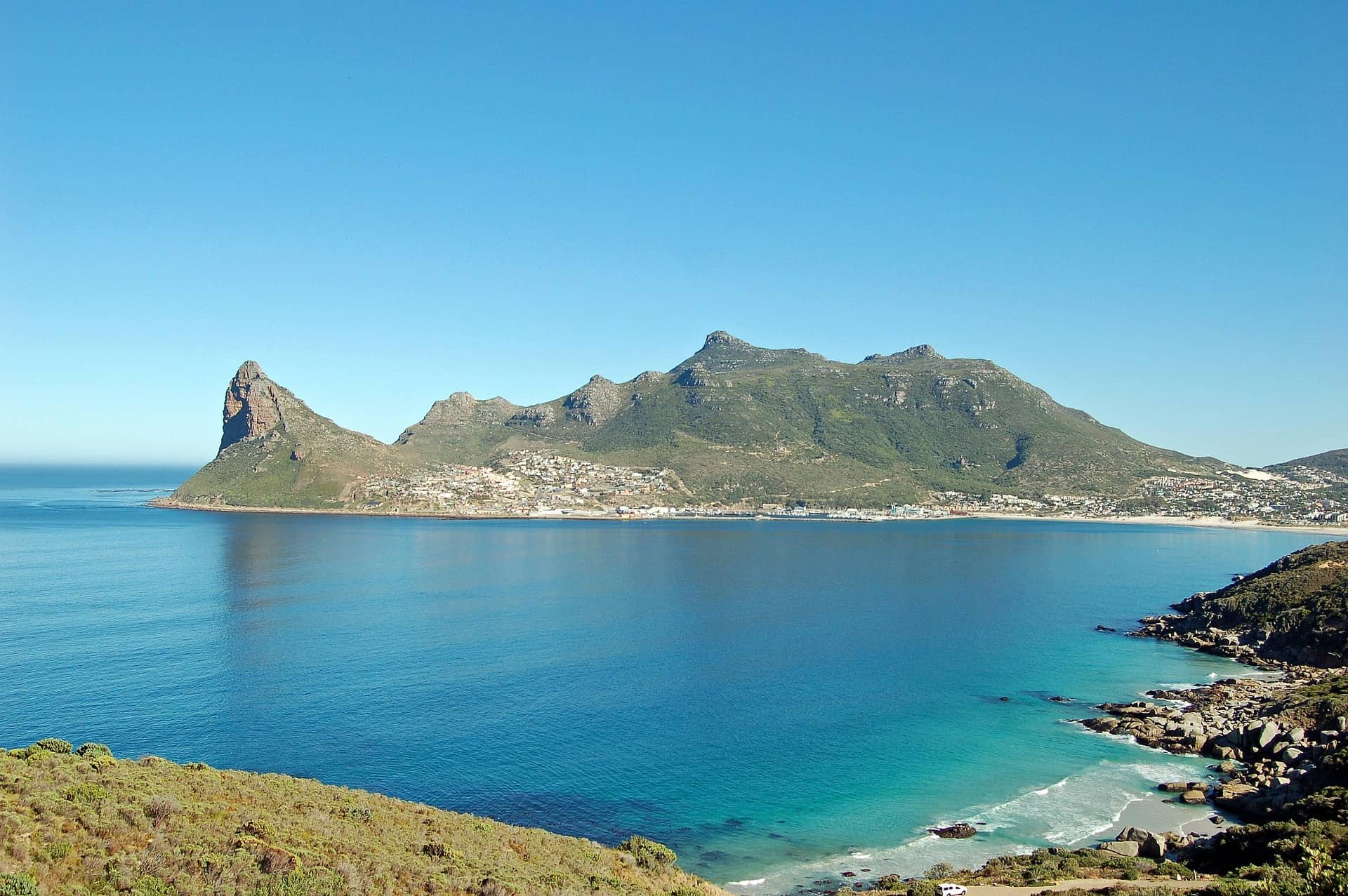 The rocks surrounded by the wavy sea under the sunlight and a cloudy sky at daytime in South Africa